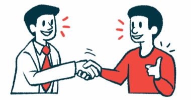 A doctor shakes hands with a patient who is making a thumbs-up gesture.